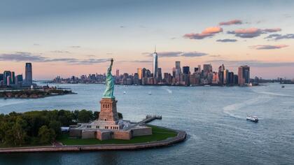 Blick auf die Freiheitsstatue dahinter die Skyline New Yorks, Mein Schiff New York Kreuzfahrt