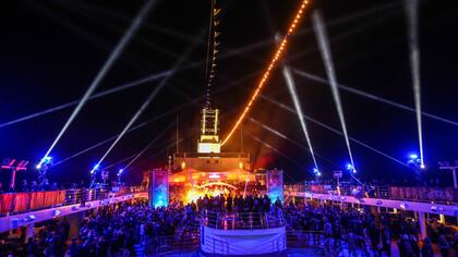 Blick auf das Deck und Publikum bei einem Konzert der Mein Schiff Full Metal Cruise bei Nacht mit Lichtshow